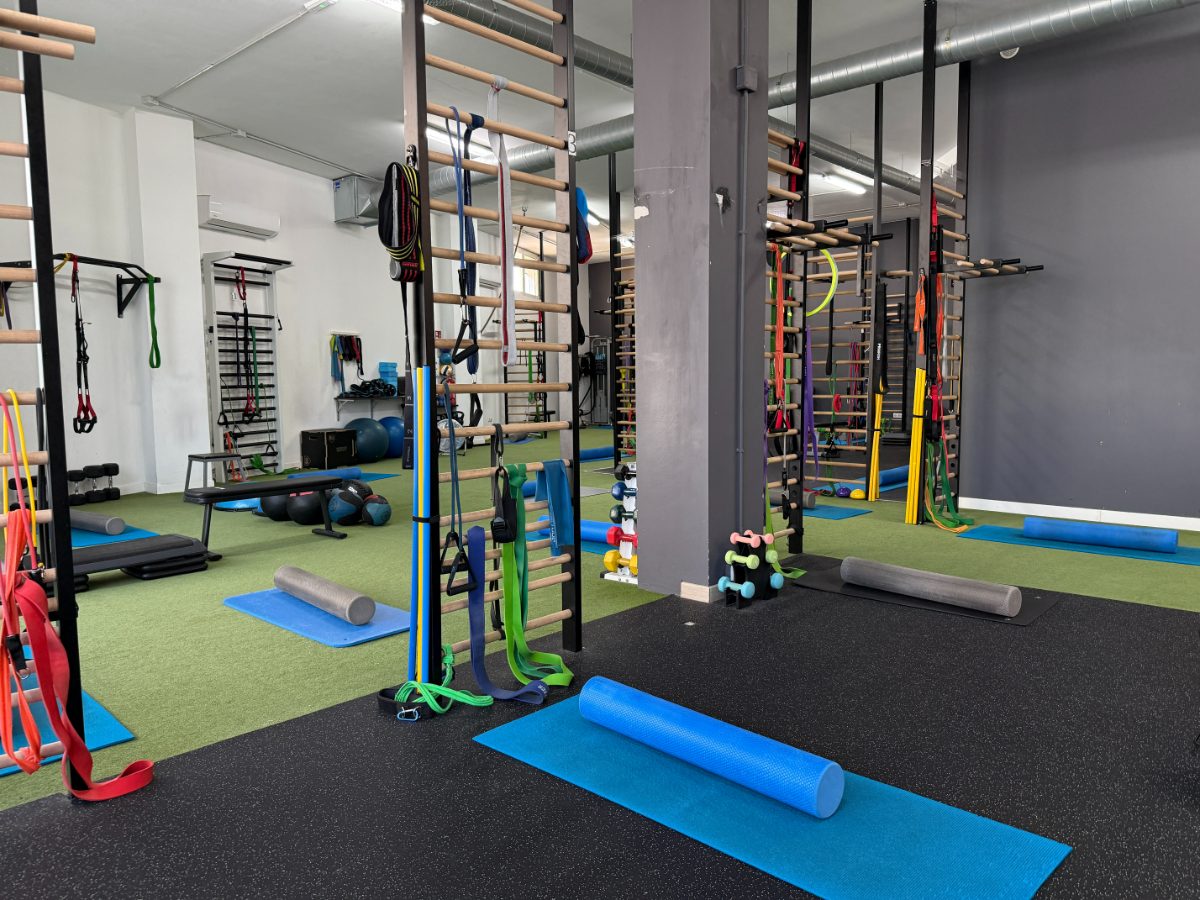 Interior de gimnasio con espalderas, bandas elásticas, rodillos de espuma y colchonetas para entrenamiento personalizado - Saludx10
